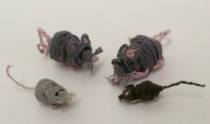 Four 3D mice made of tatting, in shades of grey and black with pink noses, ears, and tails