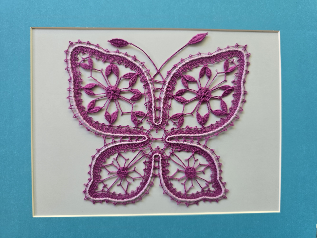 A dark pink Russian lace butterfly on a cream background